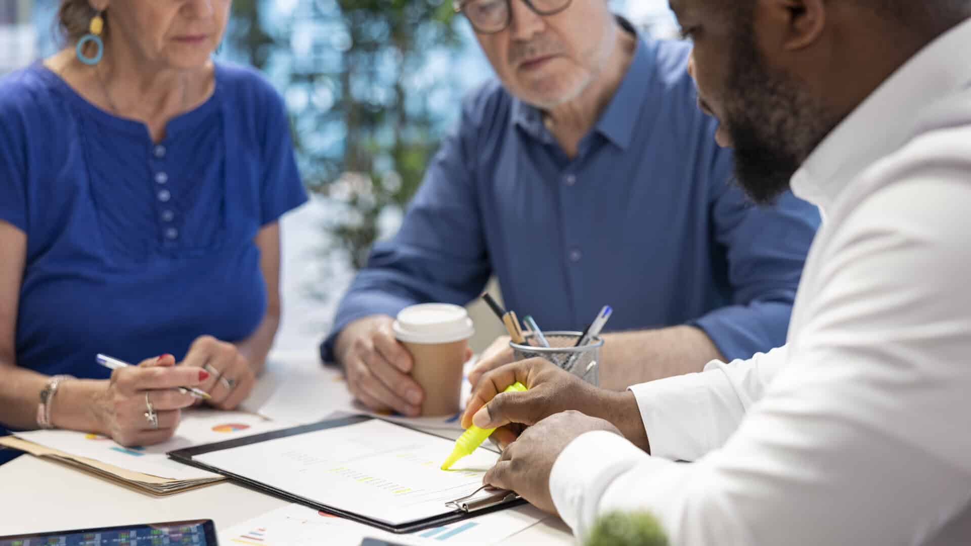 Corretora e corretores analisando termos de contrato de multicálculo de seguros