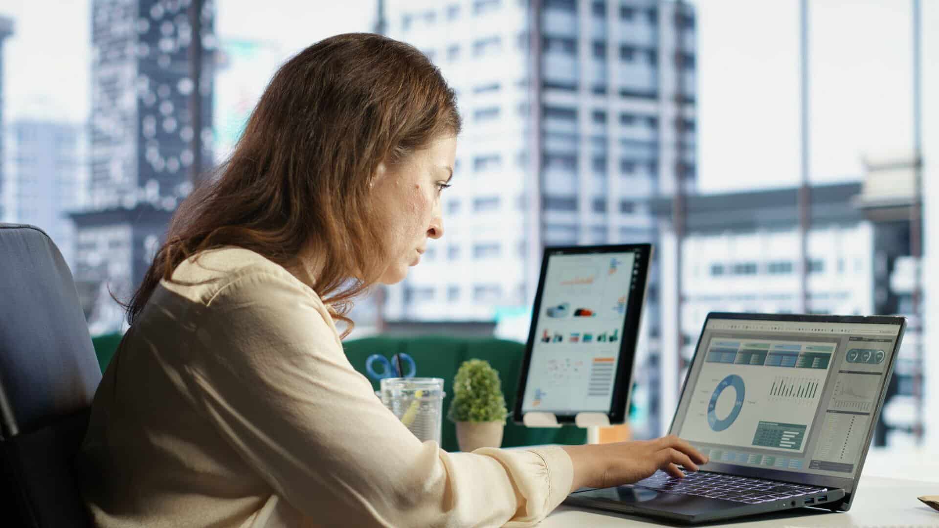 Corretor de seguros comparando plataformas de gestão e multicálculo em um notebook