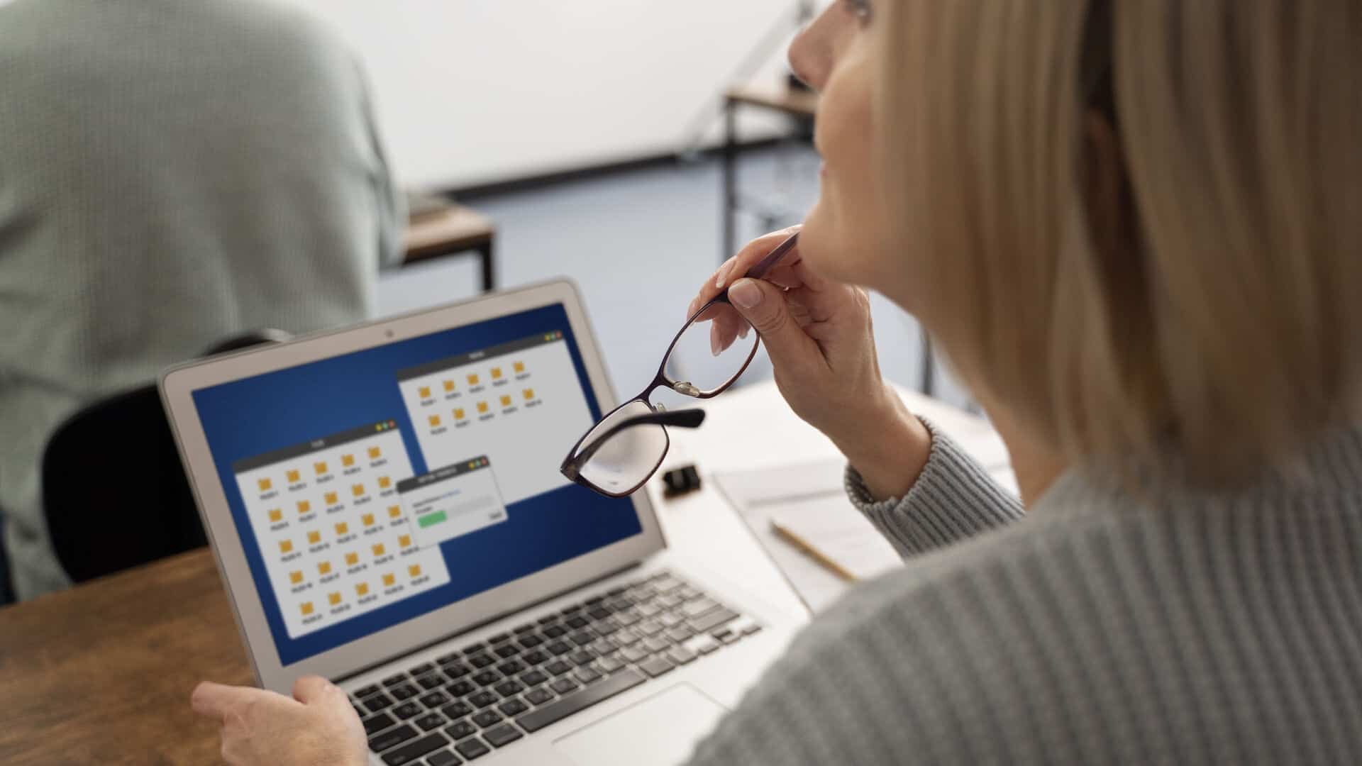 Corretora de seguros analisa planejamento de conteúdo no notebook durante reunião