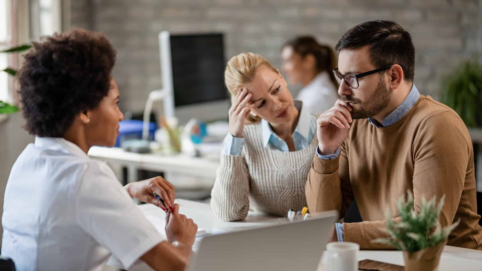 Corretora de seguros exausta durante reunião de trabalho, sinal de burnout